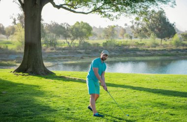 Golfçü yaz sahasında golf oynuyor.