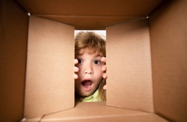 Çocuk açılış paketi. 6 yaşında bir çocuk bir kutu açıyor ve içine bakıyor, paketleri açıyor, sürpriz bir şekilde kutuları açıyor.