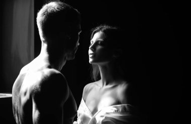 Aşık bir çift öpüşmeye gidiyor. Yakışıklı adam kadınını kucaklıyor ve öpüyor.