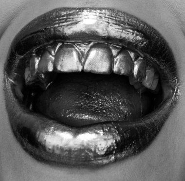 Altın ruj yakın plan. Metal makyajlı dudaklar. Seksi dudaklar, metalik ruj yakın plan.