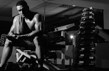 Eğitimden sonra dinleniyor. Spor salonundaki adam. Çıplak gövdeli sportif bir erkek. Antrenman adamı. Güçlü atletik vücut
