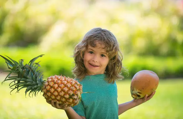 夏天小孩子在户外的肖像 笑着可爱有趣的男孩拿着菠萝和椰子 — 图库照片