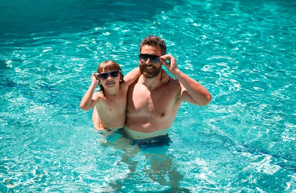 Father and son swimming in pool. Family at aquapark. Dad and son in pool. Summer weekend. Family leisure and summer vacation. Pool party
