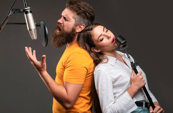 Couple duet with microphone singing song. Musician in music hall