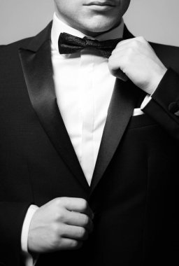 Siyah takım elbiseli bir adam papyon takıyor. Erkek modası. Klasik takım elbiseli. Zarif ve şık bir hippi.