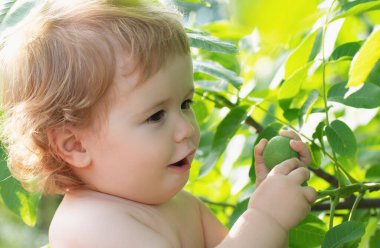 Doğa parkında yeşil yapraklı komik çocuk yüzü. Çocukların bebeklik portresi