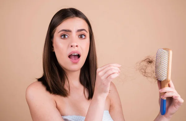 Hair loss problem treatment. Portrait of woman with a comb and problem hair