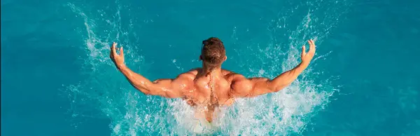 stock image Happy young man having fun at beach on sunny day. Happy sea lifestyle. Beach Clubs in Ibiza. Sexy guy in blue water on the beach. Perfect male Torso on blue water background