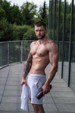 Muscular men lifting weights. Powerful male fit model doing workout in gym. Man lifting dumbells, strong athletic fit man doing exercises with dumbbells. Weightlifting workout. Fitness workout