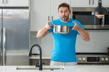 Aşçı mutfakta yemek pişiriyor. Şef aşçı tencereli bir yemek hazırlıyor. Menü tarifi sağlıklı yemek. Şef modern mutfakta yemek pişiriyor. Olgun aşçı mutfakta yemek hazırlıyor.