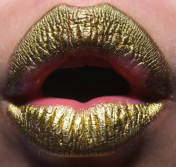 Close up female plump lips with gold. Golden glitter lipstick. Shine style for sexy lip. Sensual woman lips. Luxury golden mouth. Glamour gold lips. Golden lips with golden paint or metallic lipstick
