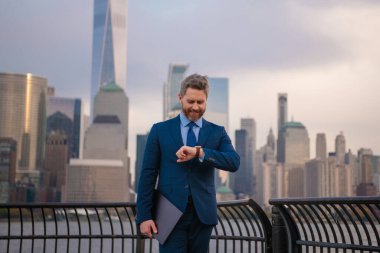 İş adamı, iş organizasyonunu yönetmek için nöbet tutuyor. Ofisin dışında dizüstü bilgisayar kullanan orta yaşlı bir iş adamı. Olgun iş adamının sokak portresi