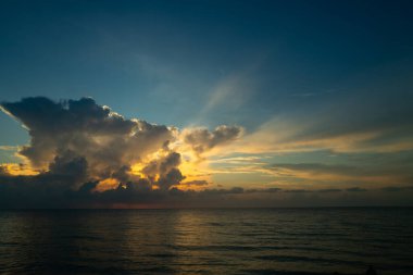 Dramatik gün batımı ve bulutlu gökyüzü. Deniz. Bulutların arasından bulutlu bulutlu bir deniz. Günbatımı okyanusu ve bulutlu gökyüzü arkaplanı. Huzurlu deniz manzarası. Günbatımı deniz suyunun üzerinde bir ufuk. Sakin bulutlu gökyüzü