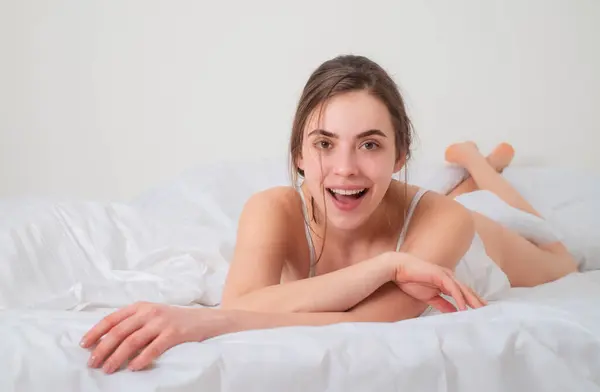 在卧室里的年轻女人躺在床上的有趣的女孩喜欢早上醒来 — 图库照片