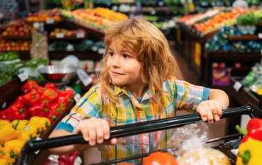 Çocuk süpermarkette alışveriş yapıyor. Çocuklar süpermarketten alışveriş yapıyor.