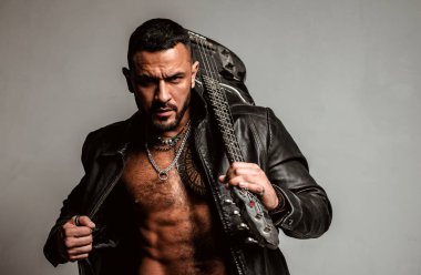 Gitarist omzunda gitar tutuyor. Elektro gitar. Müzik festivali. Sahne ve bando enstrümanları. Güçlü, kaslı, kaslı adam. Müzik konsepti