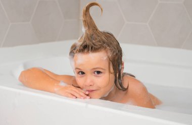 Çocuklar banyo yapar. Çocuk köpükle banyo yapıyor. Banyoda banyo yapan komik çocuk suratı.