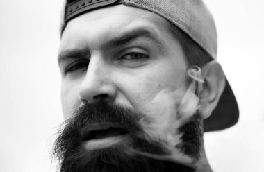 Hippi adam sigara içiyor. Tıbbi kenevir. Sigara içme alışkanlığı. Sigara içen modaya uygun olgun bir adam.