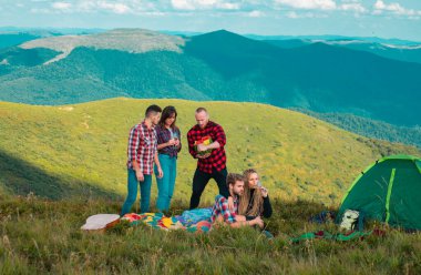 Bir grup insan dağda birlikte kamp kurarak doğa aktivitelerinin tadını çıkarıyorlar. Yaz tatilindeki öğrenciler. Kamp sezonu