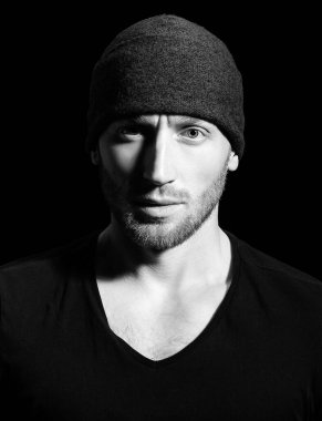 Acımasız bir adam, yakışıklı, ciddi bir erkek model. Siyahların üzerinde ciddi profil yüzü olan bir adamın yakın portresi.