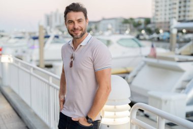 Büyük şehirde kendine güvenen yakışıklı bir adamın portresi. Sokakta poz veren sıradan giyinmiş seksi bir adam. Şehir yaşam tarzında başarılı bir erkek model. Kafkasyalı orta yaşlı adam dışarıda.