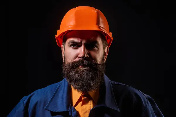 Portrait worker in construction helmet. Builder foreman or repairman in builder uniform. Worker in studio. Construction manager, builder in helmet. Male builder engineer