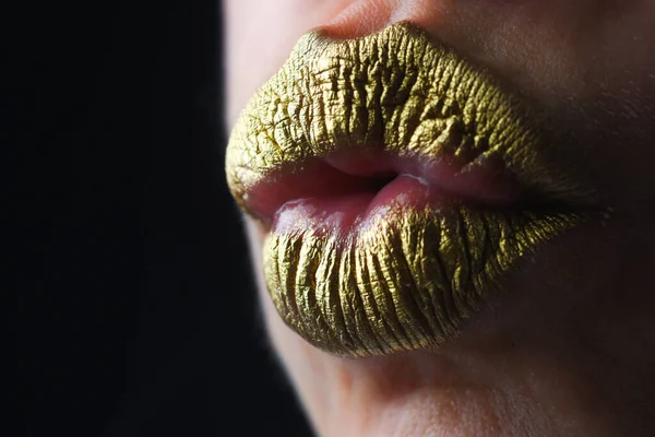 Kiss. Gold lips, golden lipgloss on sexy lips, metallic mouth. Beauty woman mouth. Sexy girl golden lips, gold mouth. Glowing gold skin and gild lips. Metallic shine golden lip gloss