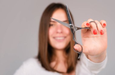 Saç kestirirken makasınızı kapatın. Profesyonel makasla düz saçlı güzel bir kız. Saç bakım konsepti, seçici odaklanma