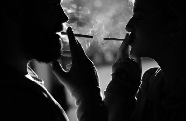 Sigarayı rahatlatmak için duraklat. Çift huzur içinde sigara içmek için yer bulmak. Her nefesin tadını çıkarıyorum. Sigara alışkanlığı. Tütün endüstrisi. Kadın sigara kentsel arka plan sigara.