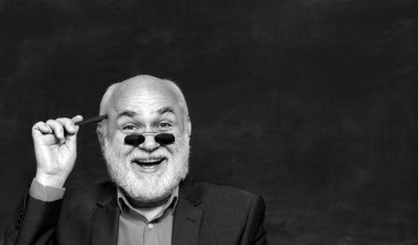 Karatahta masasının yanındaki sınıfta dost canlısı bir öğretmen. Eğitim ve öğrenim insanları kavramı - kadın öğretmen tahtaya yakın. Öğretmenler günü. Teşekkürler öğretmenim.