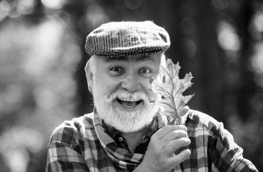 Portrait of a senior man outdoors walking in a park. Happy senior man looking at camera. Autumn and active holidays. Autumn portrait of grandfather