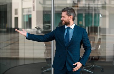 Klasik takım elbise giyen başarılı bir ofis çalışanının portresi. Mutlu ve heyecanlı kazanan el kol kaldırma hareketi, başarılı iş adamı