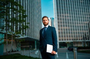 Ofis binaları arasında başarılı, kendinden emin bir iş adamı. İş adamı portresi. Finans bölümünün kendine güvenen müdürü.