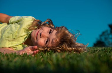 Çocuk çim tarlasında eğleniyor ve hayal kuruyor