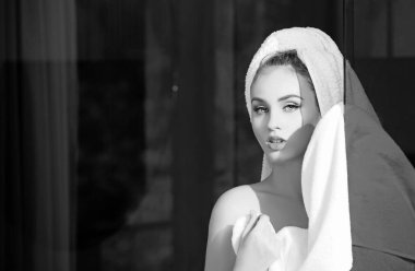 Banyodan veya duştan sonra genç bir kadın. Kafasında beyaz havlu olan bir kız omuz omuza, çıplak makyaj, güzel bir fotoğraf. Havlulu çıplak kız.