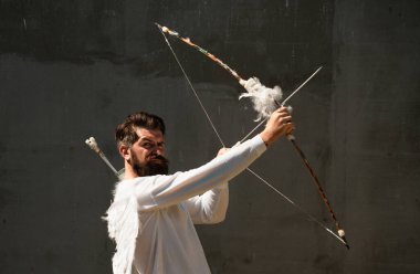 Ok ve yayla nişan alan kanatlı bir aşk tanrısı. Komik Sevgililer Günü konsepti