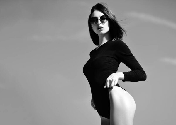 Sexy girl foreplay. Hot babe. Elegant chic female model in fashion sunglasses. Young woman posing. Concept of beauty. Advertising and commercial design. Attractive