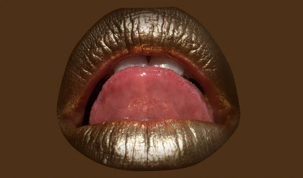 Shine golden style for sexy lips. Gold paint on lip. Golden sensual woman mouth. Metallic creative art lipstick close up. Gold concept. Sexy tongue. Sensual lick. Glamour background