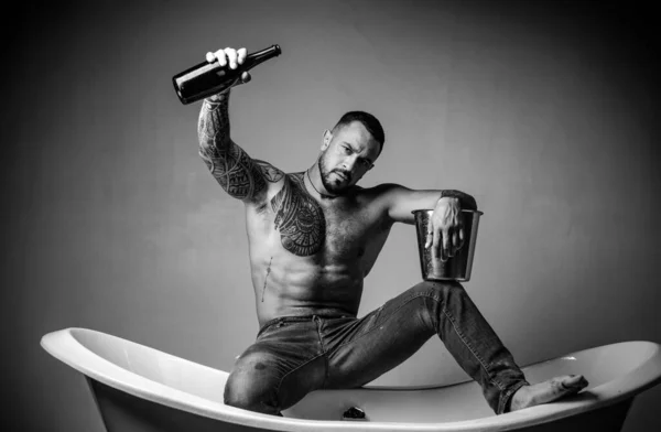 男人在性感派对上喝着一瓶灰色背景的香槟 — 图库照片