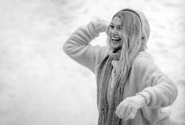 Kış kadını. Açık havada ilk karın tadını çıkaran sevimli, oynak genç bir bayan. Mutlu genç kız kartopu savaşı oynuyor. Eldivenli kız kartopu tutar