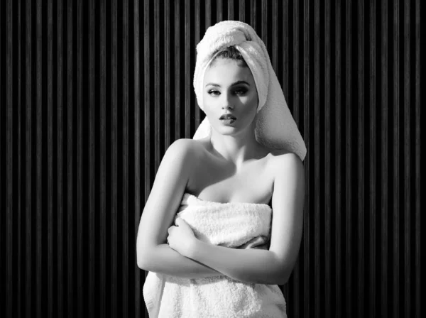 Beautiful woman handle towel, after bath. Beauty portrait of half naked woman with a towel wrapped around her head looking at camera