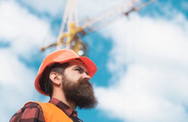 İş kıyafetleri içinde inşaat işçisi ve miğfer. İnşaat ve inşaat alanı kavramı