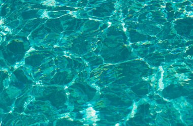 Su arka planı, dalgalanma dalgaları. Mavi yüzme havuzu deseni. Deniz yüzeyi. Yüzme havuzunda su ve güneş yansıması. Kopyalama alanı olan pankart