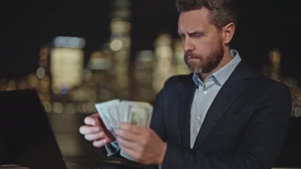 ナイトストリートでお金を数えるスーツを着た男 ニューヨークでドル紙幣を数える アメリカの金融 マンハッタンの夜にお金 ニューヨークでのキャッシュ ナイトビジネス — ストック動画