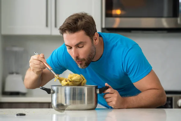 Male cook or chef cooking food in pan pot in kitchen. Process of preparing gourmet dish. Man cooking at home in kitchen, using pot. Chef cooking food. Handsome chef cook cooking concept