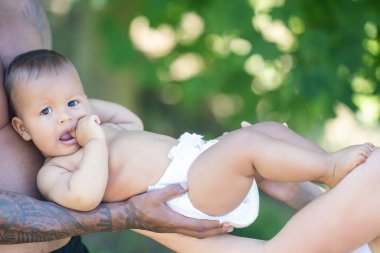 Çok ırklı ebeveynler ve karışık ırk bebekleri. Karışık ırk, çok ırklı, açık havada çekilmiş aile portresi. Çift ırklı bir bebek. Çok güzel bir aile. Çok ırklı aile parkta birlikte eğleniyor.