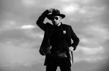 Kovboy şapkalı bir kovboy. Vahşi batı silahları, eski tabanca tabancası ve federal mühimmatı olan ciddi bir adam. Amerikan batı şerifi. Vahşi batı konsepti