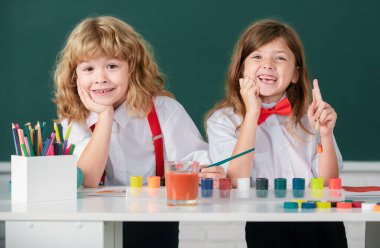 Resim okulu öğrencileri resim ödevi yapıyor. Çocuklar ilkokulda resim çiziyor. Çocukluk eğitimi, çocukların sanatsal becerileri.