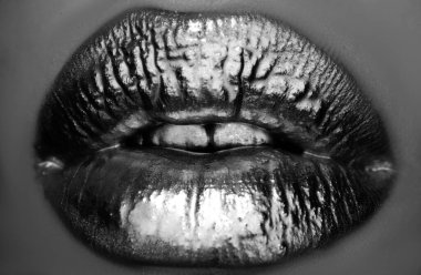 Altın dudaklar, seksi dudaklarda altın ruj, metalik ağız. Güzellik kadın makyajı yakın çekim. Dudaklarda altın etkisi