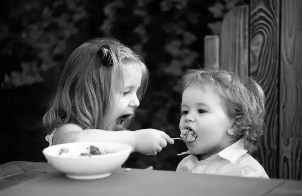妹が赤ん坊に餌をやる かわいい面白い赤ちゃんが食べる 赤ちゃんの食べ物 健康的な子供の朝食 食欲あり — ストック写真